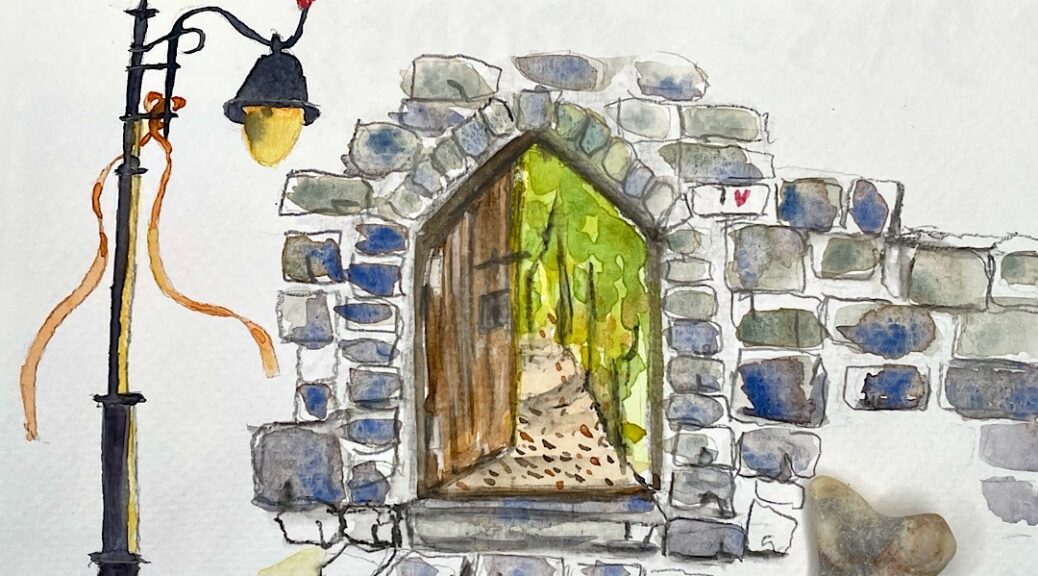 Tor in einer Steinmauer, welches in einen grünen Garten führt.AC